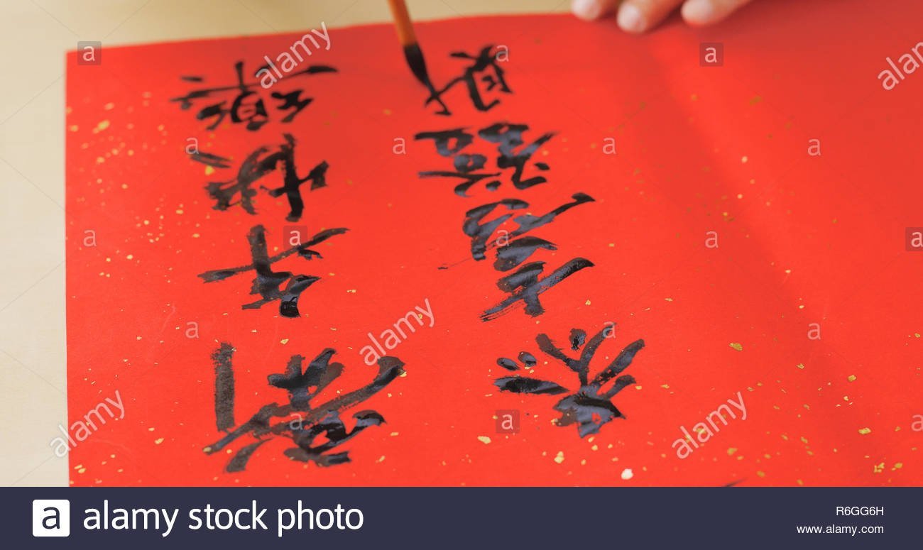 Writing Chinese Calligraphy On Red Paper For Lunar New Year Stock